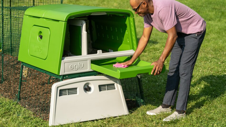 Man cleaning his Eglu Cube Chicken Coop