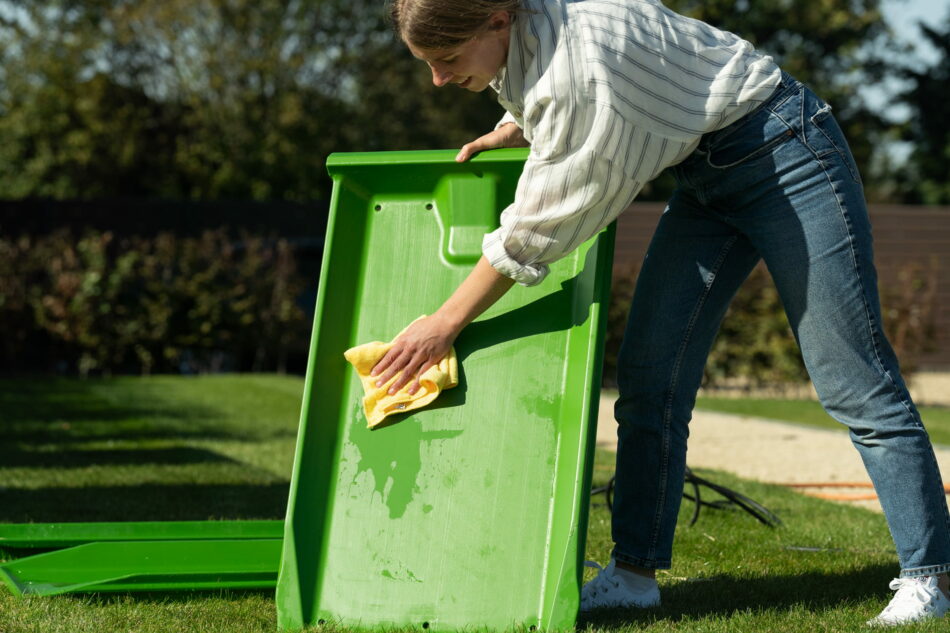 woman wiping down eglu droppings tray
