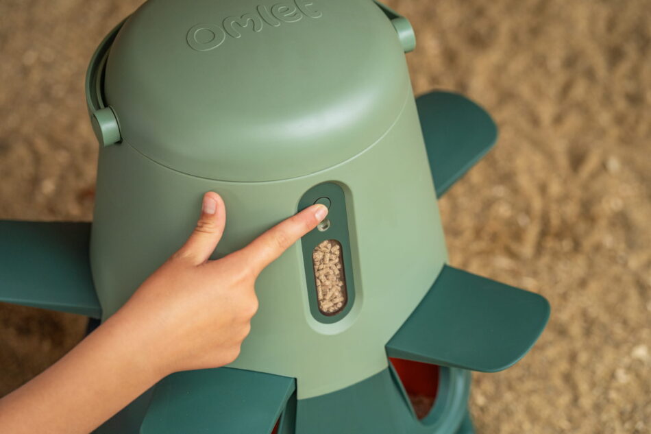 person closing smart feeder using button