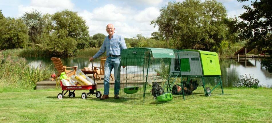 Chicken coop ideas - man with Omlet Eglu Cube Chicken Coop and accessories