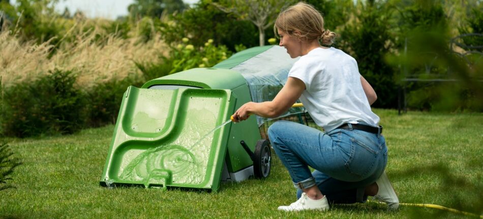 Rabbit owner cleaning the easy-to-clean Omlet Eglu Go rabbit hutch