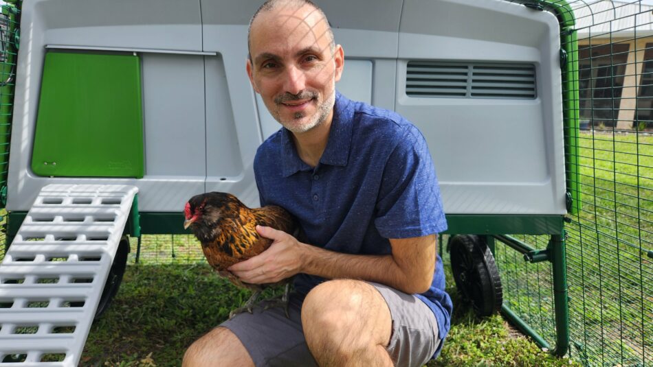 Omlet-Botschafter Jeremy Gary aus Florida/USA mit einem Huhn vor dem Eglu Pro