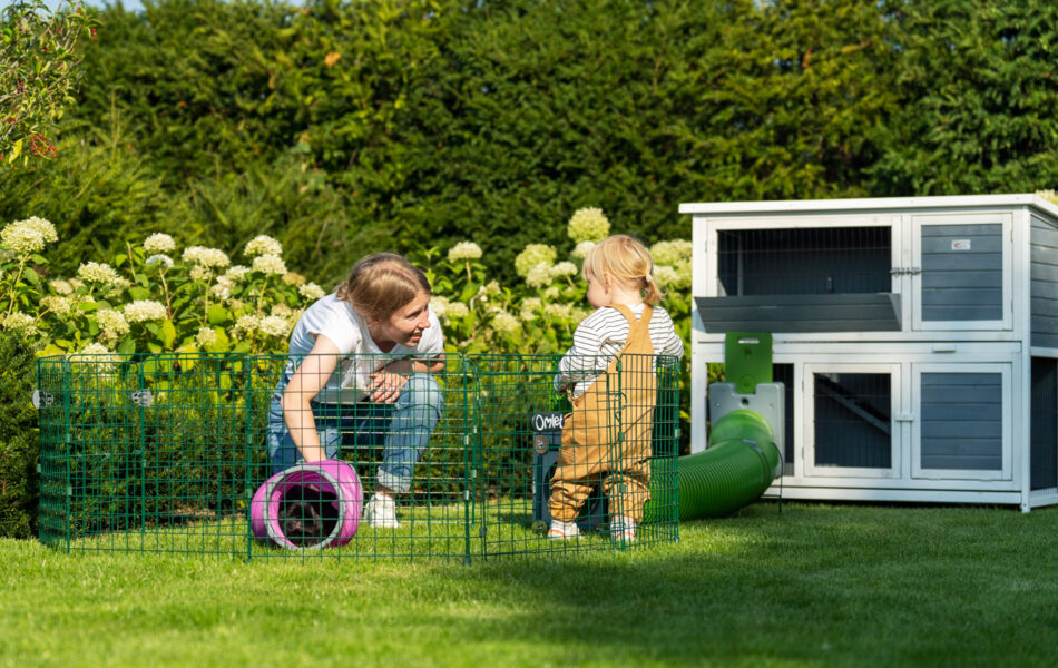 Woman and child playing with rabbit in the Omlet playpen