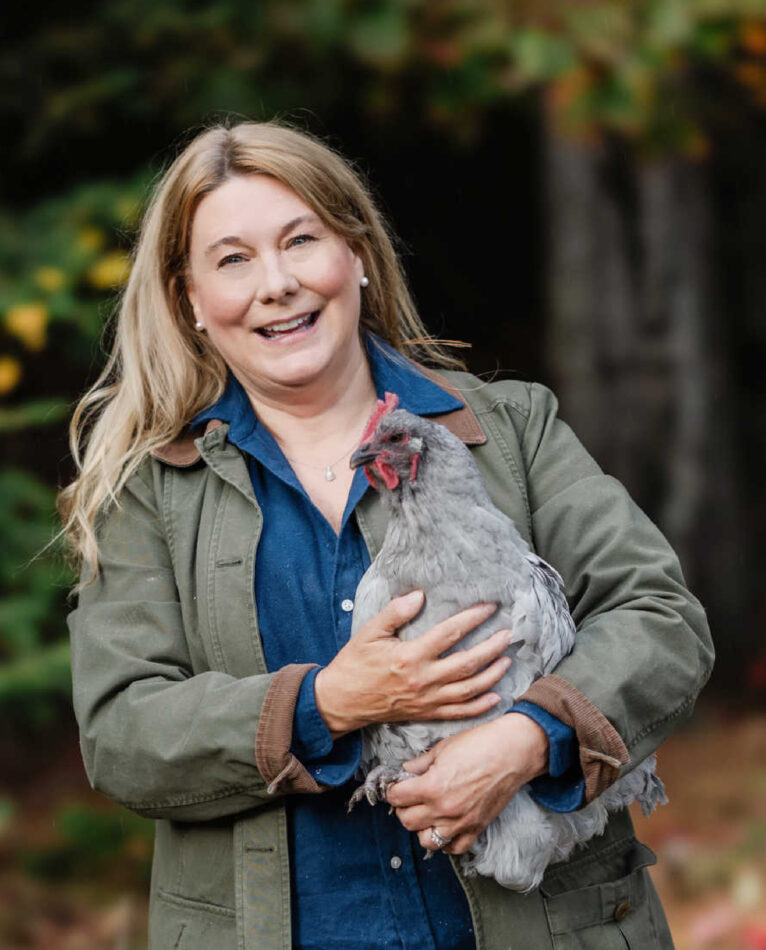 Woman smiling and holding her hen