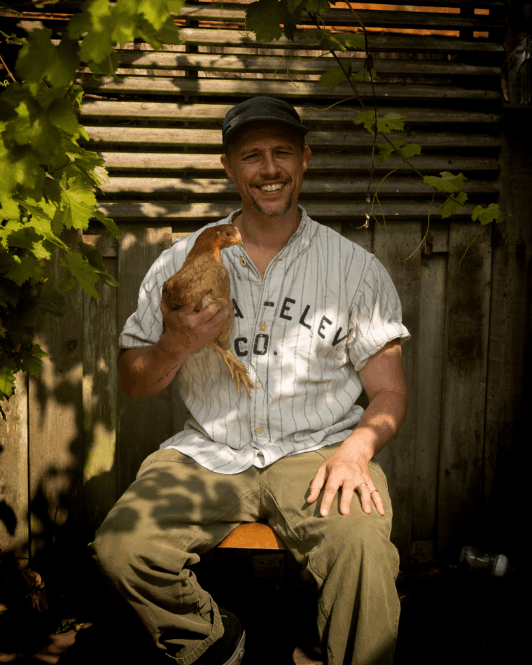 JP Cooper sat with chicken in arm